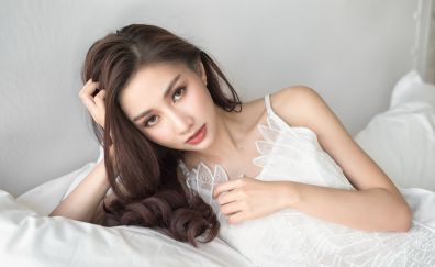 Asian woman, white clothing, bed
