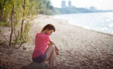 At beach, short jeans, woman model, sitting