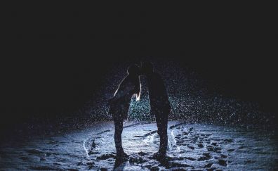 Kissing couple in rain at romantic night