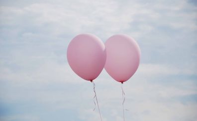 Two pink balloons in air